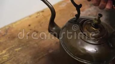 人的特写`从木板上拿出一个旧铁壶。 概念。 博物馆展览